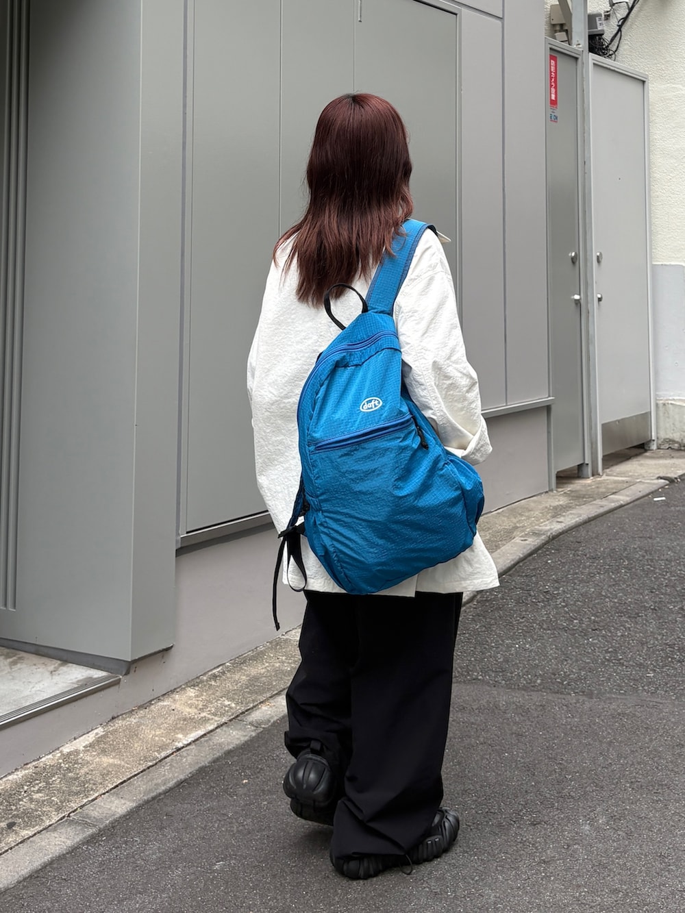 ブラック系のその他パンツ、ブラック系のバックパック/リュック、ブラウン系のタンクトップを着用したレディースの夏コーディネートの3枚目の写真