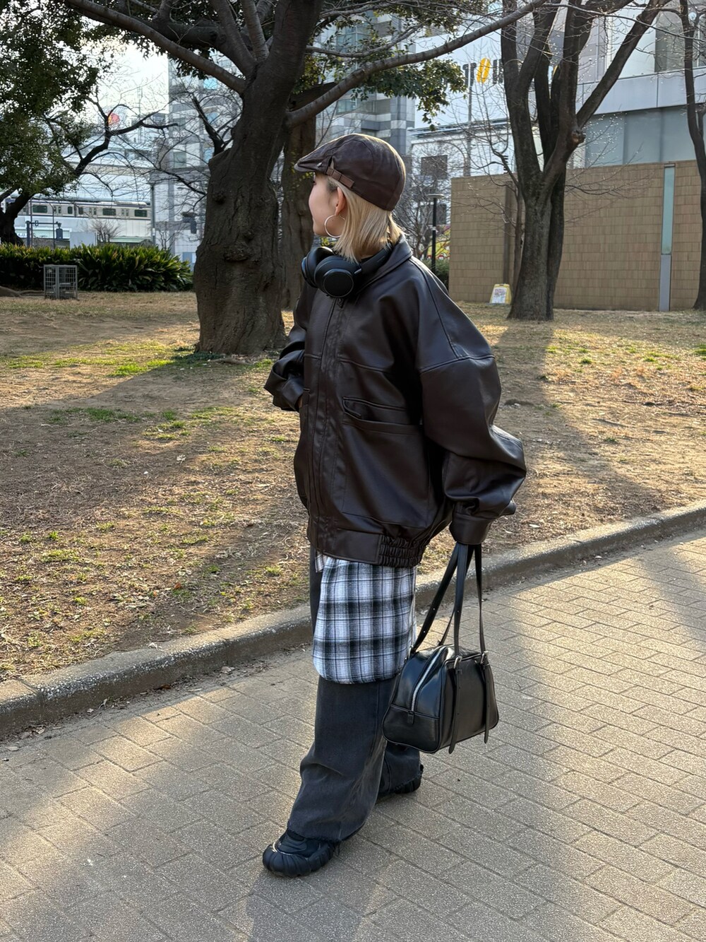 ブラウン系のブルゾン、グレー系のシャツ/ブラウス、ブラック系のデニムパンツを着用したレディースの春コーディネートの2枚目の写真