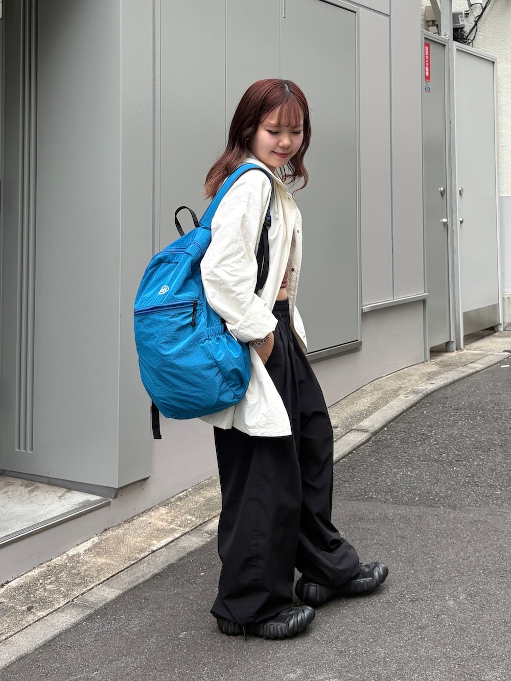 ブラック系のその他パンツ、ブラック系のバックパック/リュック、ブラウン系のタンクトップを着用したレディースの夏コーディネートの2枚目の写真