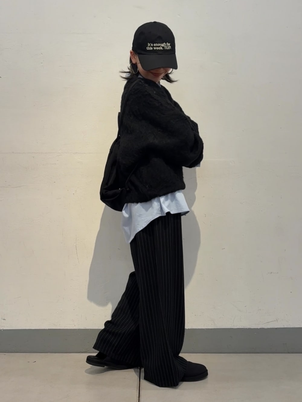 ブラック系のニット/セーター、ブルー系のシャツ/ブラウス、ブラック系のサンダルを着用したレディースの秋コーディネートの2枚目の写真