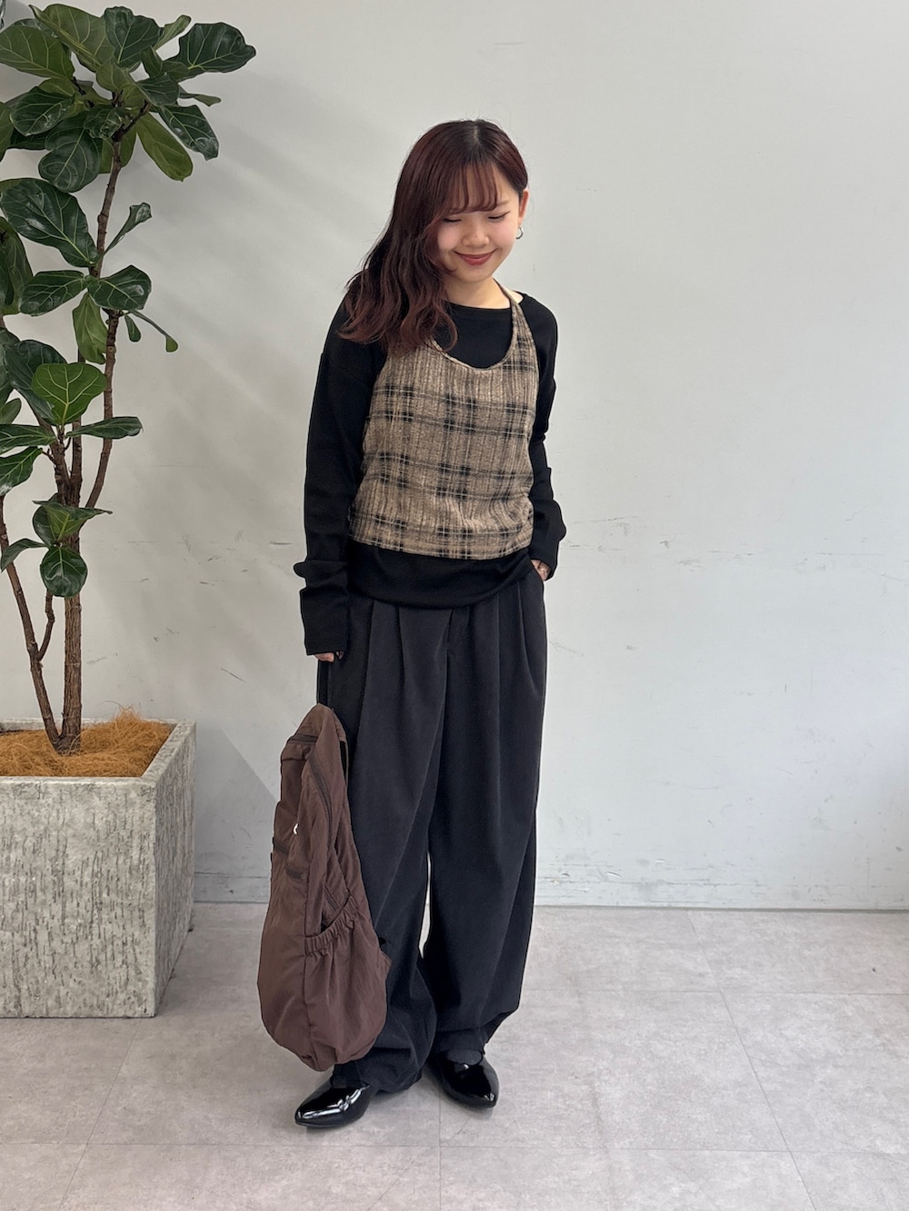 グレー系のその他パンツ、ブラウン系のバックパック/リュック、ブラック系のTシャツ/カットソーを着用したレディースの秋コーディネートの3枚目の写真