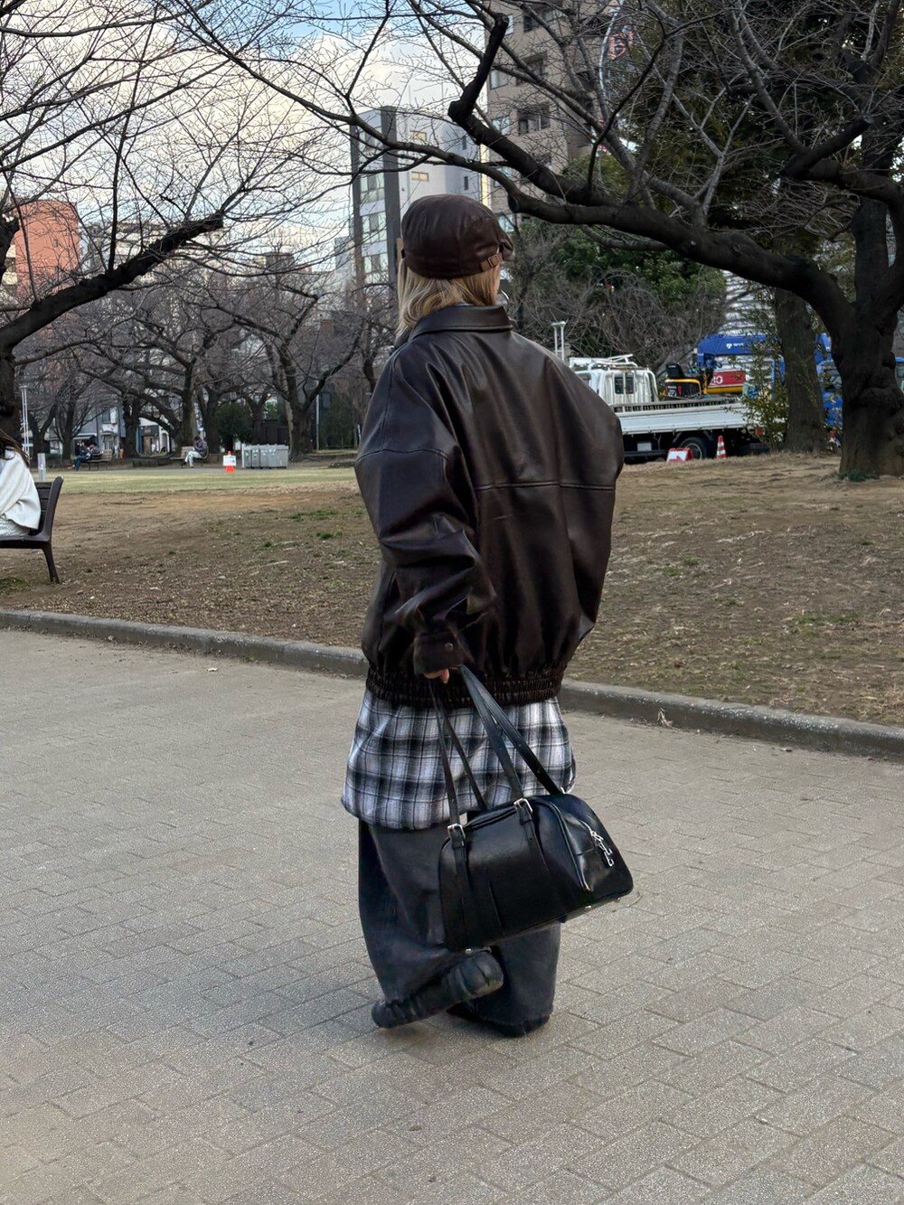 ブラウン系のブルゾン、グレー系のシャツ/ブラウス、ブラック系のデニムパンツを着用したレディースの春コーディネートの3枚目の写真