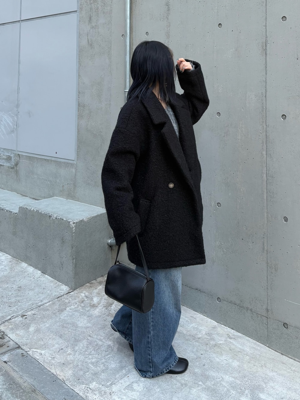 ブラック系のハンドバッグ、グレー系のカーディガン/ボレロ、ブルー系のデニムパンツを着用したレディースの秋コーディネートの4枚目の写真