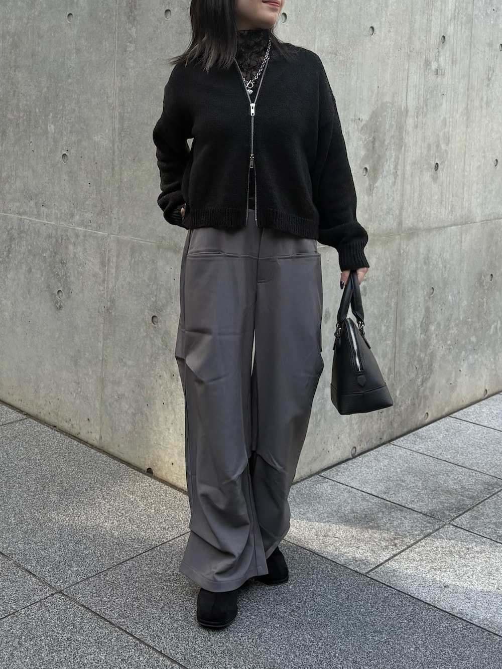 ブラック系のカーディガン/ボレロ、ブラック系のTシャツ/カットソー、ブラック系のバックパック/リュックを着用したレディースの春コーディネートの2枚目の写真