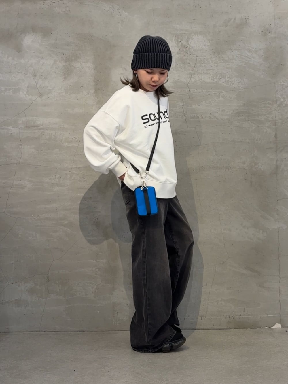 ブラック系のボディバッグ/ウエストポーチ、ブラック系のデニムパンツ、ホワイト系のTシャツ/カットソーを着用したレディースの秋コーディネートの2枚目の写真