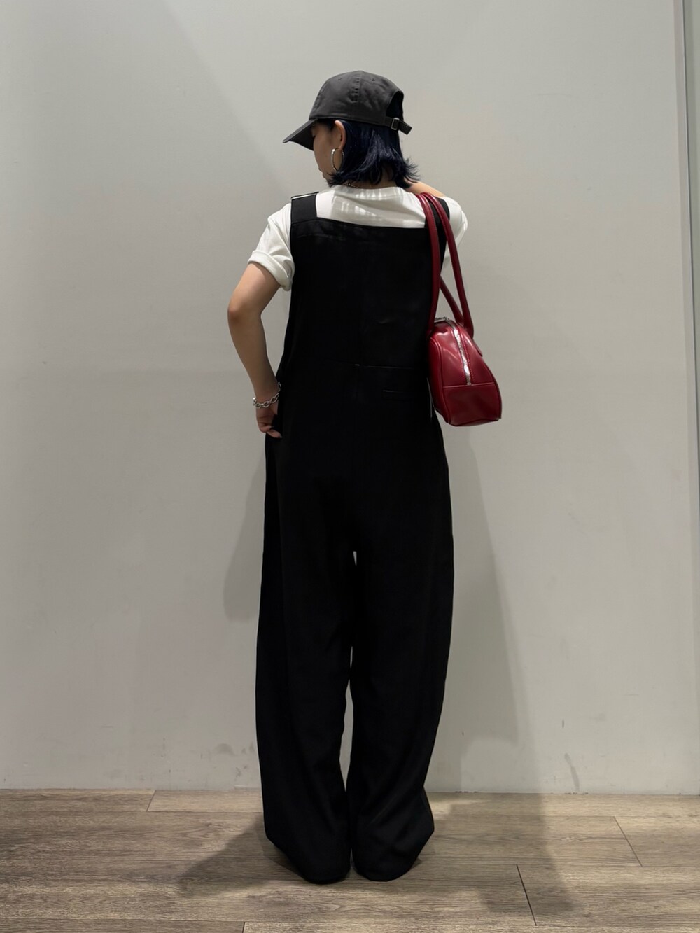 ブラック系のサロペット/オーバーオール、ホワイト系のTシャツ/カットソー、レッド系のボストンバッグを着用したレディースの夏コーディネートの3枚目の写真