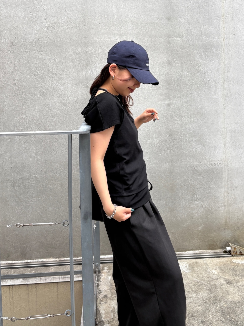ブラック系のTシャツ/カットソー、ブラック系のショルダーバッグ、ブラック系のスラックスを着用したレディースの夏コーディネートの4枚目の写真