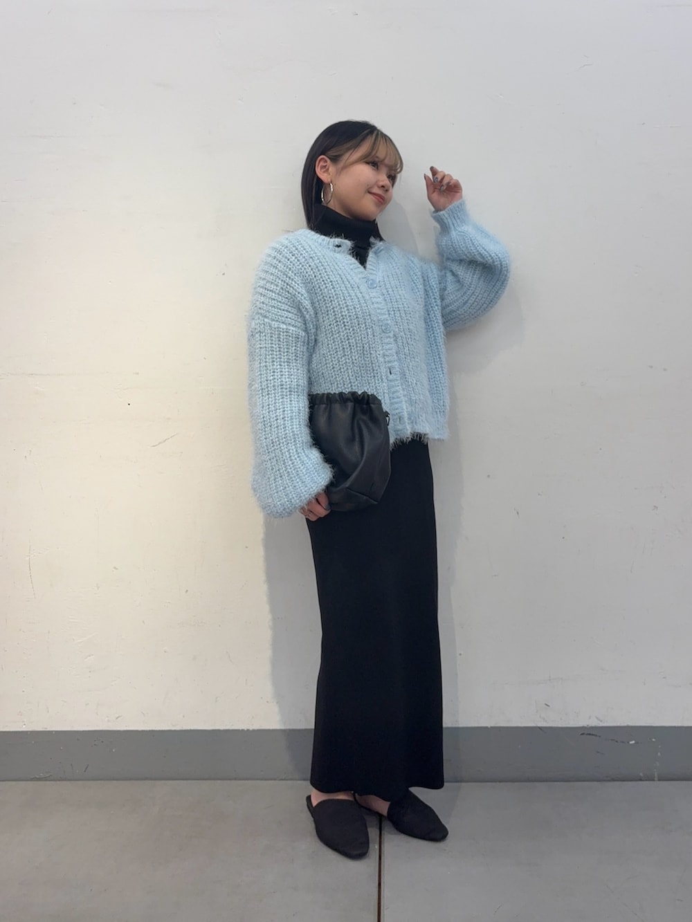 ブラック系のスカート、ブラック系のサンダル、ブラック系のショルダーバッグを着用したレディースの冬コーディネートの2枚目の写真