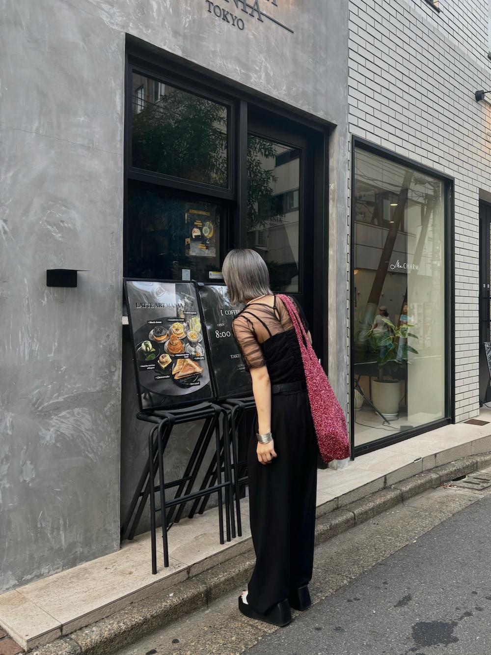 ブラック系のチューブトップ、ブラック系のスラックス、ブラック系のTシャツ/カットソーを着用したレディースの夏コーディネートの3枚目の写真