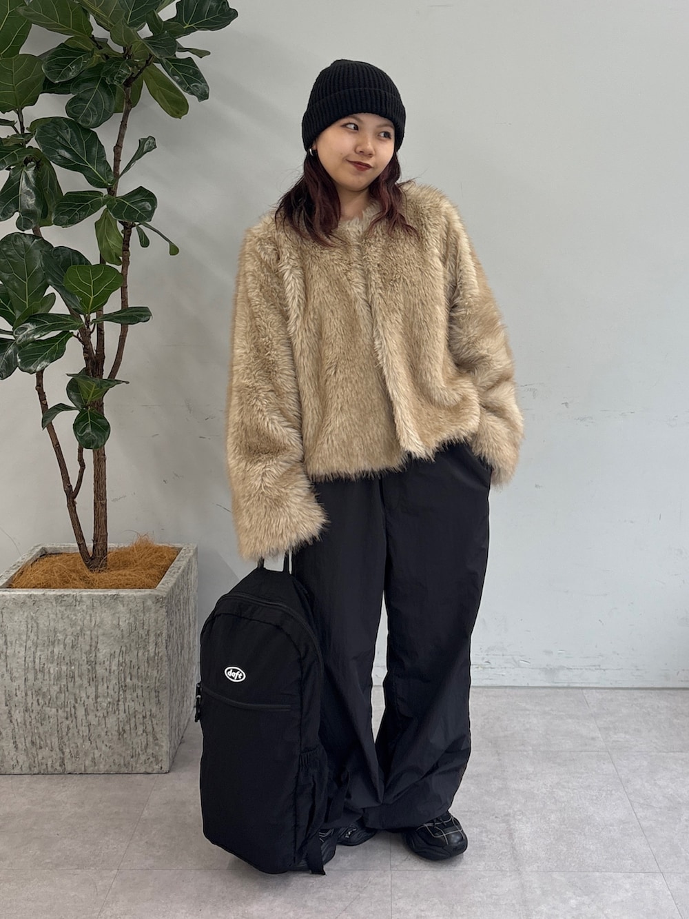 ブラック系のバックパック/リュック、グレー系のその他パンツ、ホワイト系のその他アウターを着用したレディースの秋コーディネートの2枚目の写真