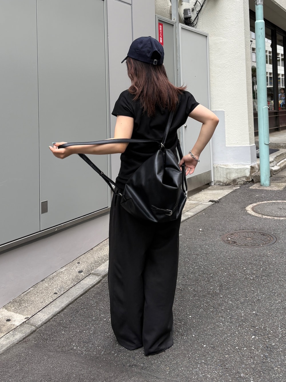 ブラック系のTシャツ/カットソー、ブラック系のショルダーバッグ、ブラック系のスラックスを着用したレディースの夏コーディネートの5枚目の写真