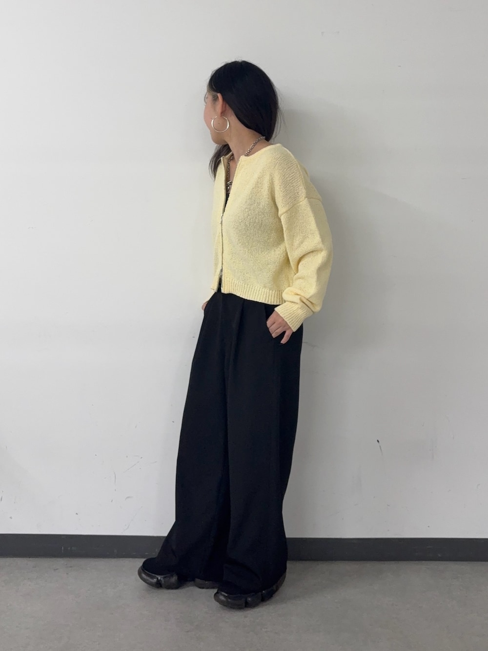 グレー系のスラックス、イエロー系のカーディガン/ボレロを着用したレディースの春コーディネートの2枚目の写真