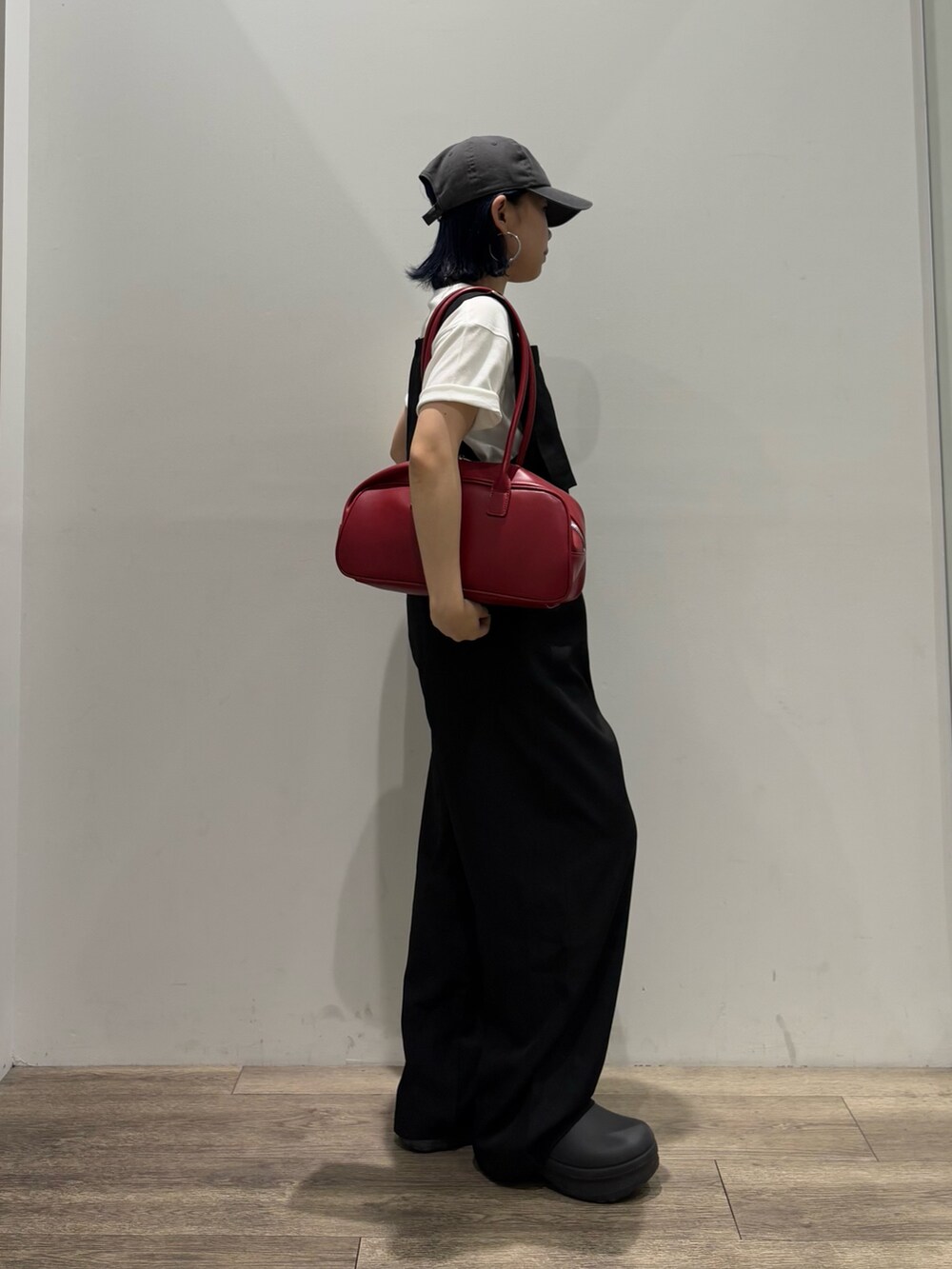 ブラック系のサロペット/オーバーオール、ホワイト系のTシャツ/カットソー、レッド系のボストンバッグを着用したレディースの夏コーディネートの2枚目の写真