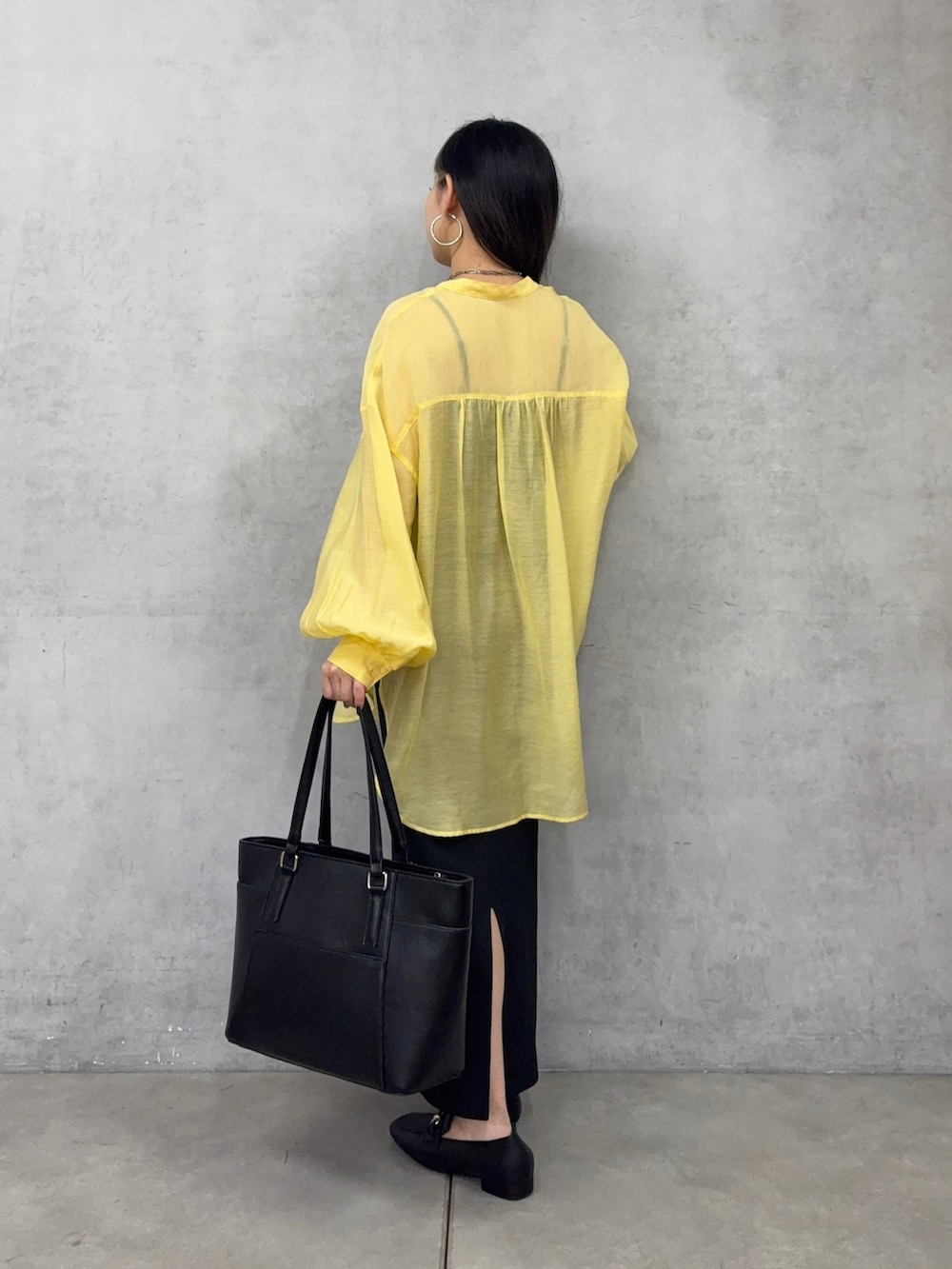 ブラック系のトートバッグ、ブラック系のスカート、ブラック系のシャツ/ブラウスを着用したレディースの春コーディネートの3枚目の写真