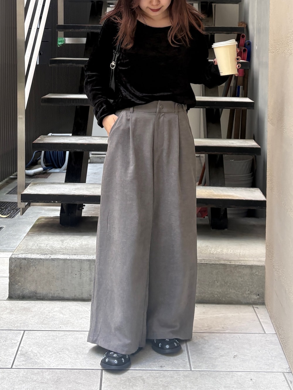 グレー系のスラックス、ブラック系のトートバッグ、ブラック系のTシャツ/カットソーを着用したレディースの夏コーディネートの6枚目の写真
