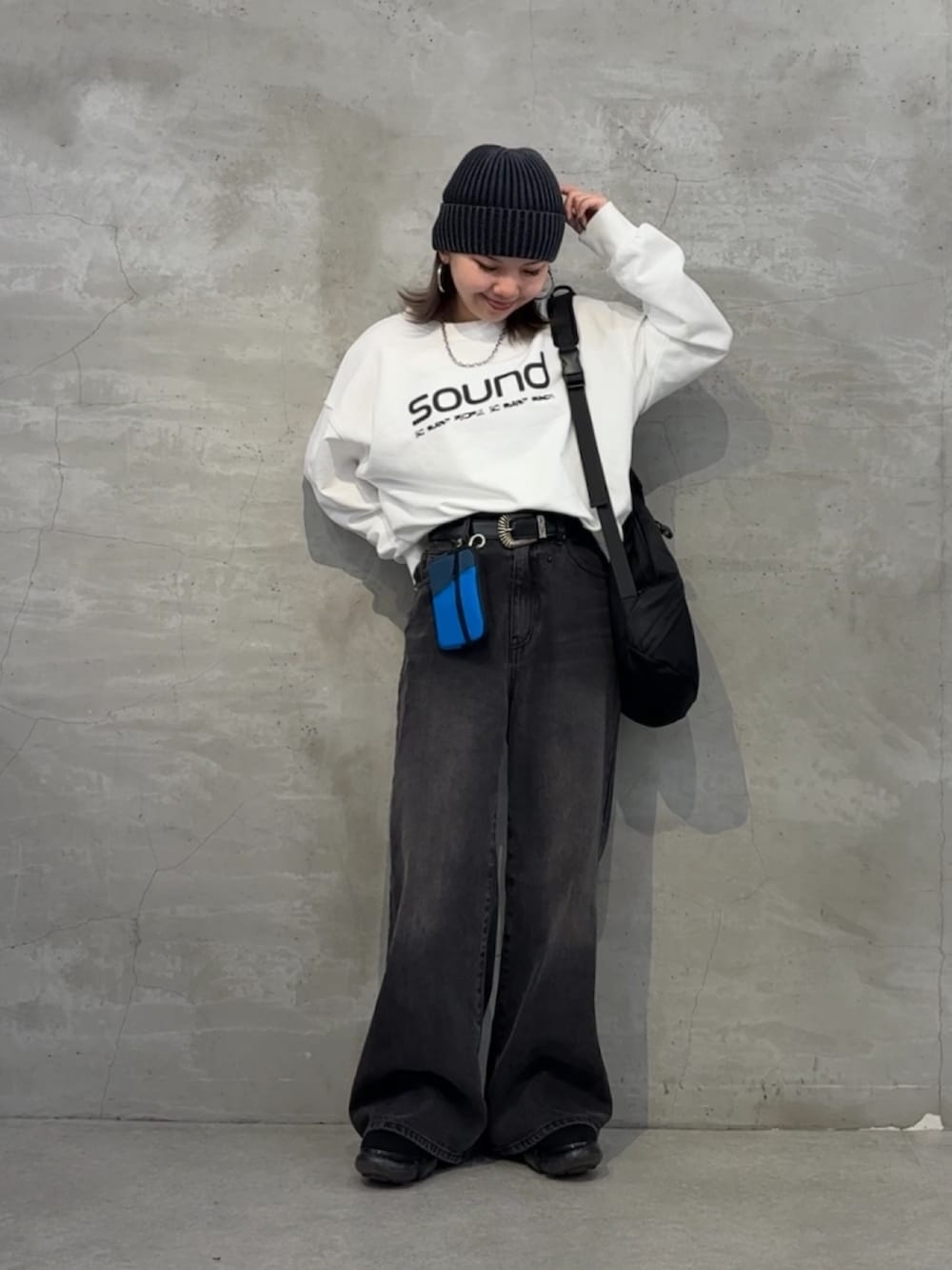 ブラック系のボディバッグ/ウエストポーチ、ブラック系のデニムパンツ、ホワイト系のTシャツ/カットソーを着用したレディースの秋コーディネートの3枚目の写真