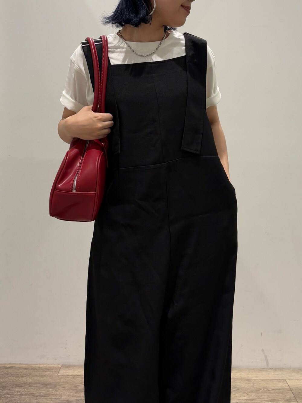 ブラック系のサロペット/オーバーオール、ホワイト系のTシャツ/カットソー、レッド系のボストンバッグを着用したレディースの夏コーディネートの4枚目の写真