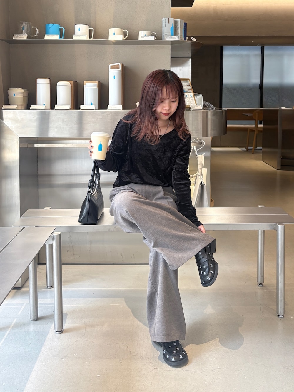 グレー系のスラックス、ブラック系のトートバッグ、ブラック系のTシャツ/カットソーを着用したレディースの夏コーディネートの5枚目の写真