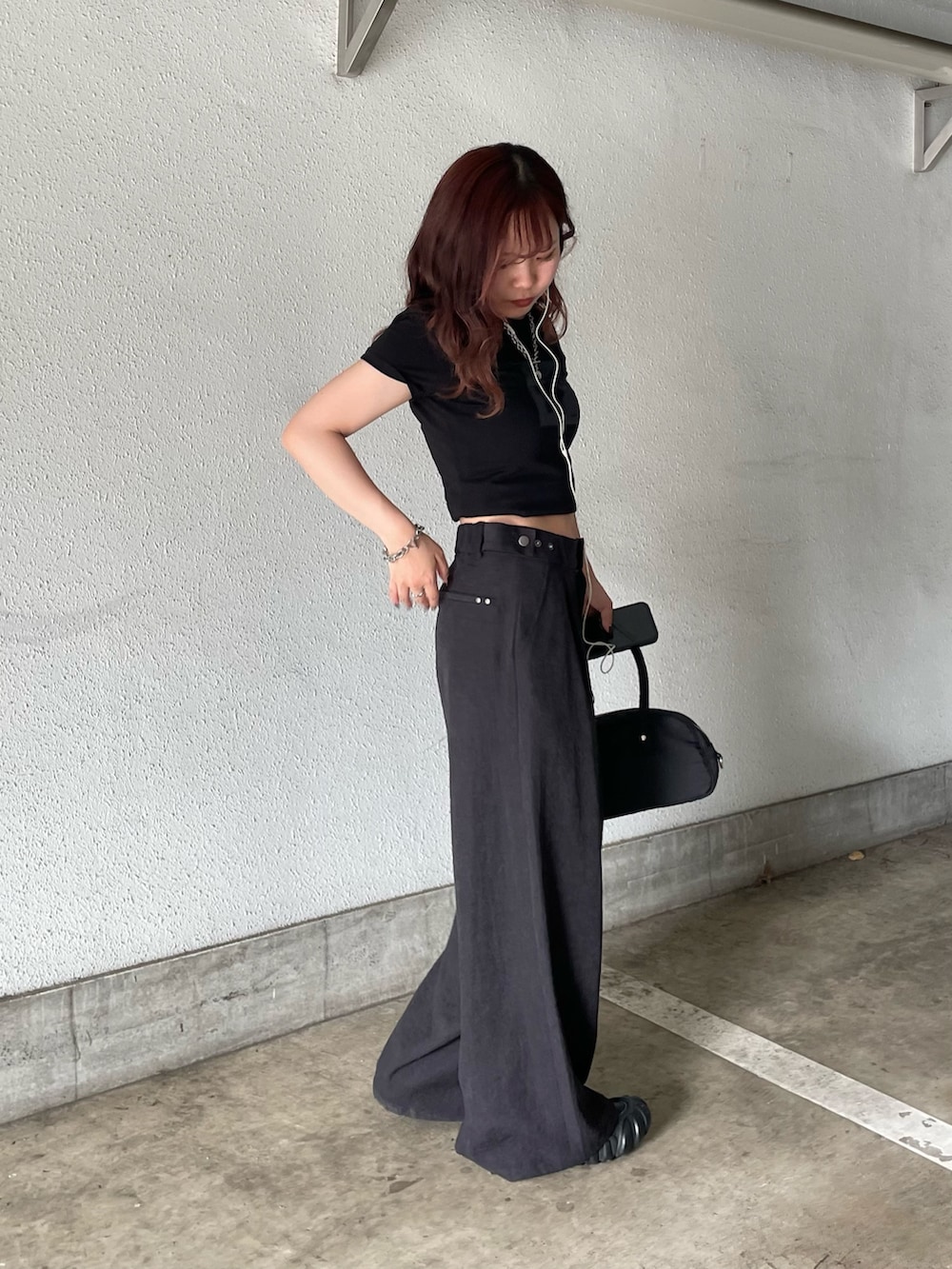 ブラック系のスラックスを着用したレディースの夏コーディネートの2枚目の写真