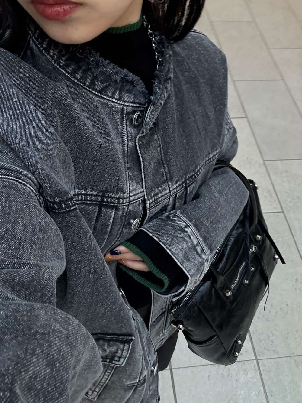 ブラック系のニット/セーター、ブラック系のデニムジャケット、ブラック系のショルダーバッグを着用したレディースの春コーディネートの5枚目の写真