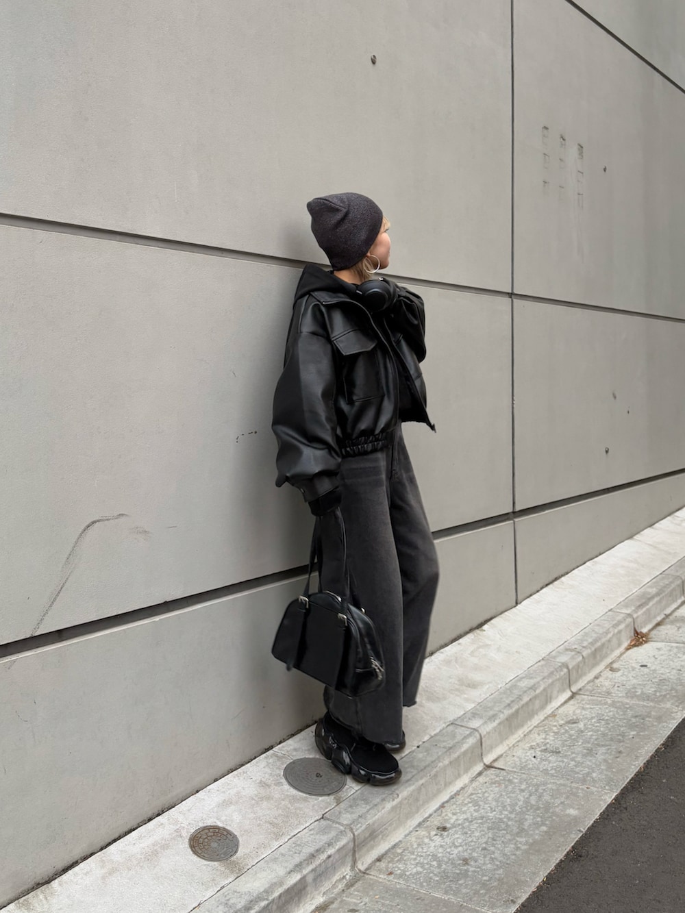 ブラック系のデニムパンツ、ブラック系のライダースジャケット、ブラック系のTシャツ/カットソーを着用したレディースの冬コーディネートの2枚目の写真