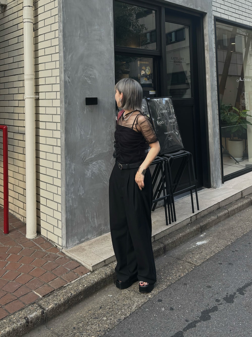 ブラック系のチューブトップ、ブラック系のスラックス、ブラック系のTシャツ/カットソーを着用したレディースの夏コーディネートの2枚目の写真