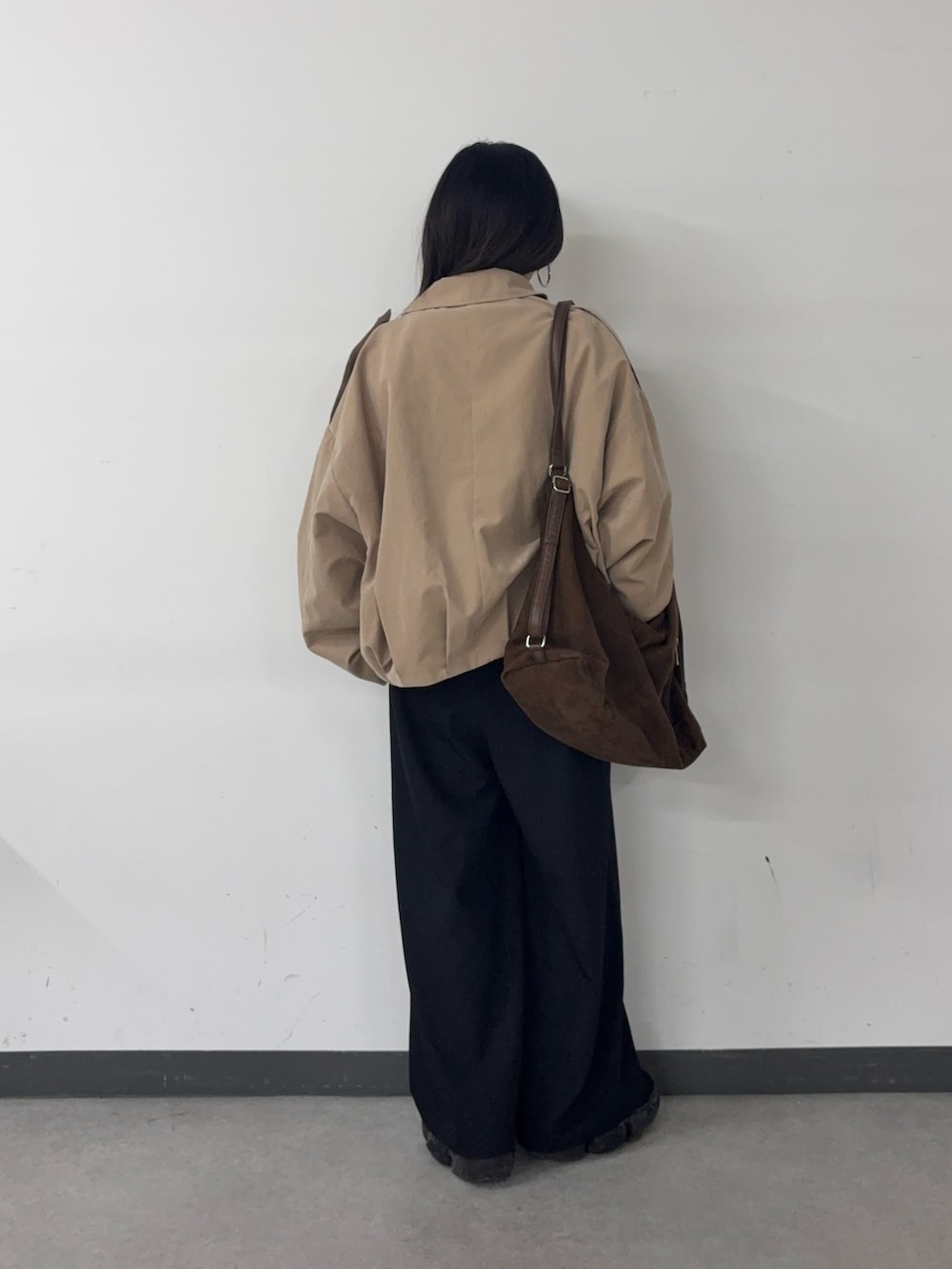 ブラック系のスラックス、ブラウン系のショルダーバッグ、イエロー系のカーディガン/ボレロを着用したレディースの春コーディネートの3枚目の写真