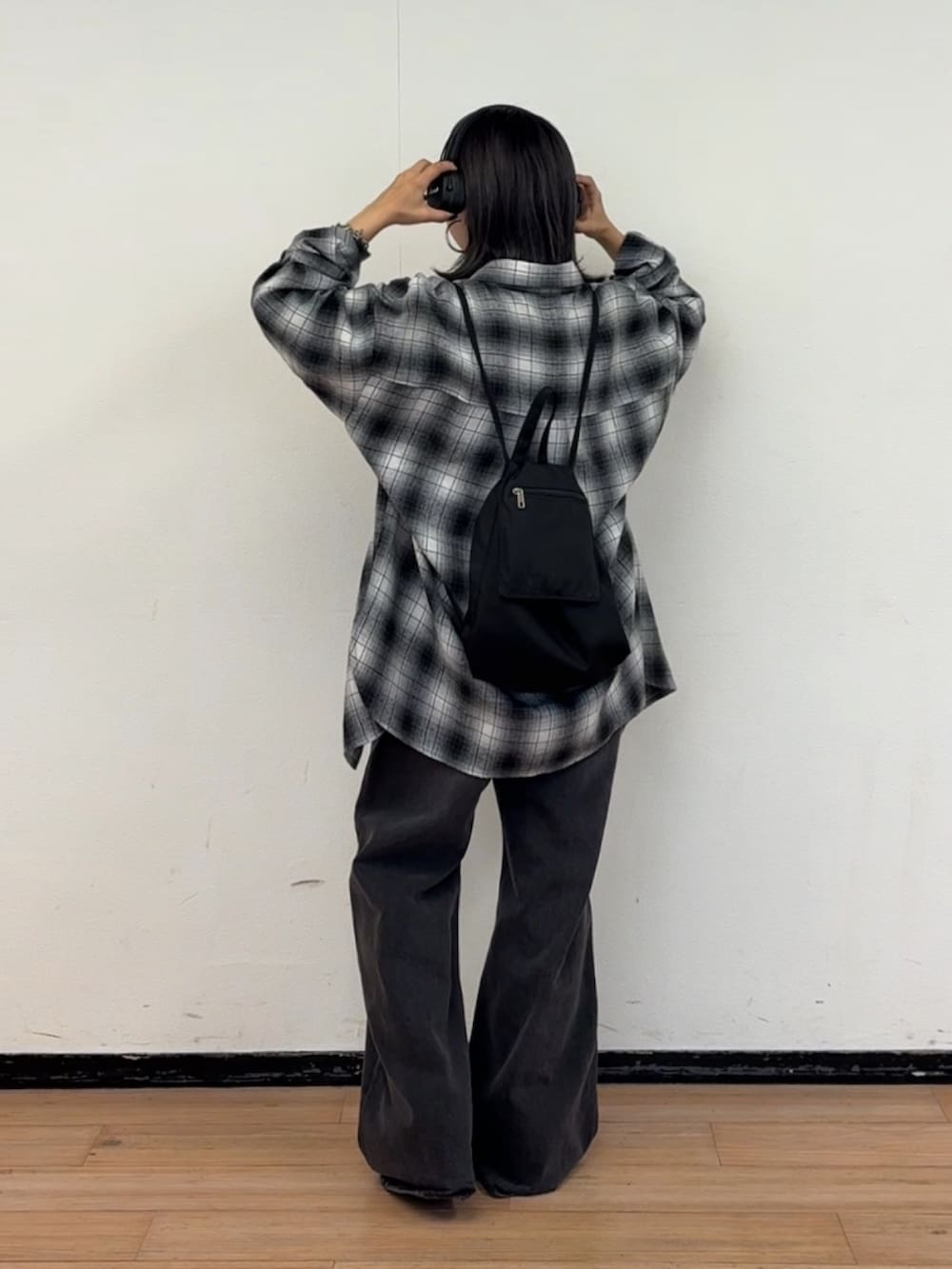 ブラック系のデニムパンツ、ブラック系のバックパック/リュック、ブラック系のシャツ/ブラウスを着用したレディースの秋コーディネートの3枚目の写真