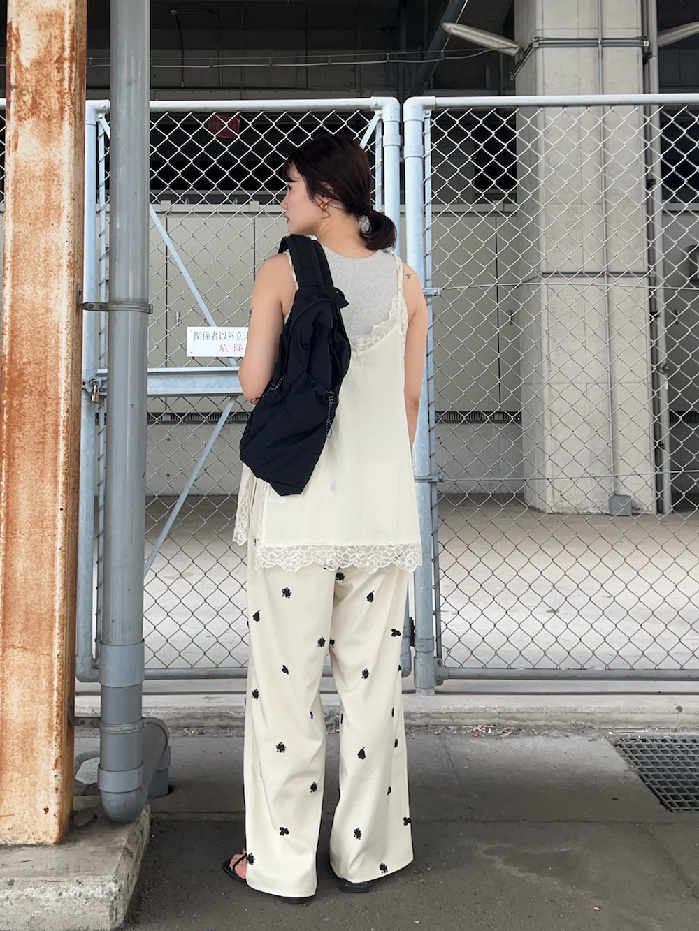 ホワイト系のその他パンツ、ホワイト系のキャミソール、ブラック系のバックパック/リュックを着用したレディースの夏コーディネートの2枚目の写真