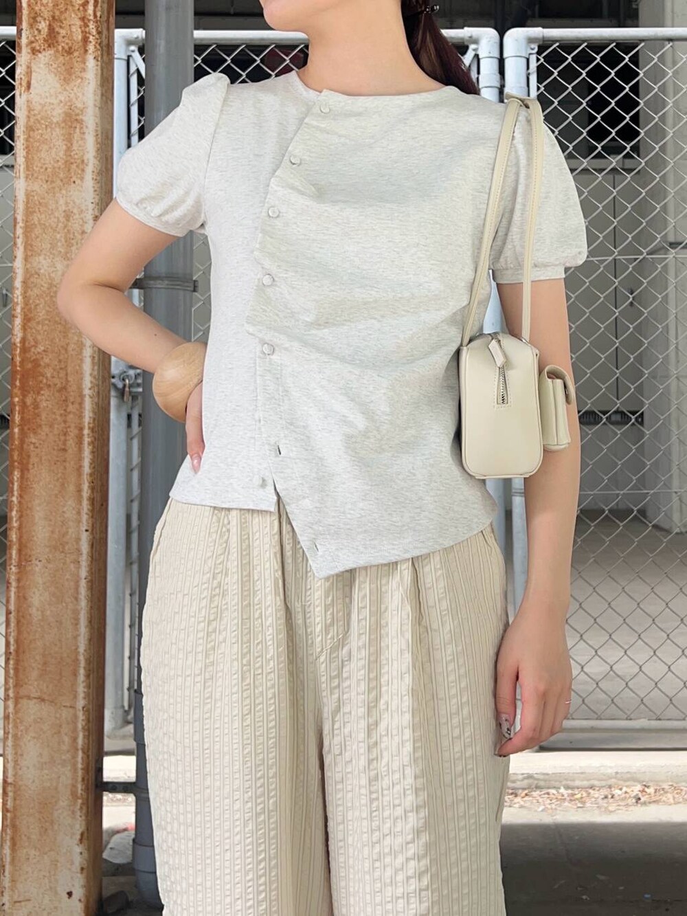 ホワイト系のショルダーバッグ、ベージュ系のその他シューズ、ベージュ系のTシャツ/カットソーを着用したレディースの春コーディネートの3枚目の写真