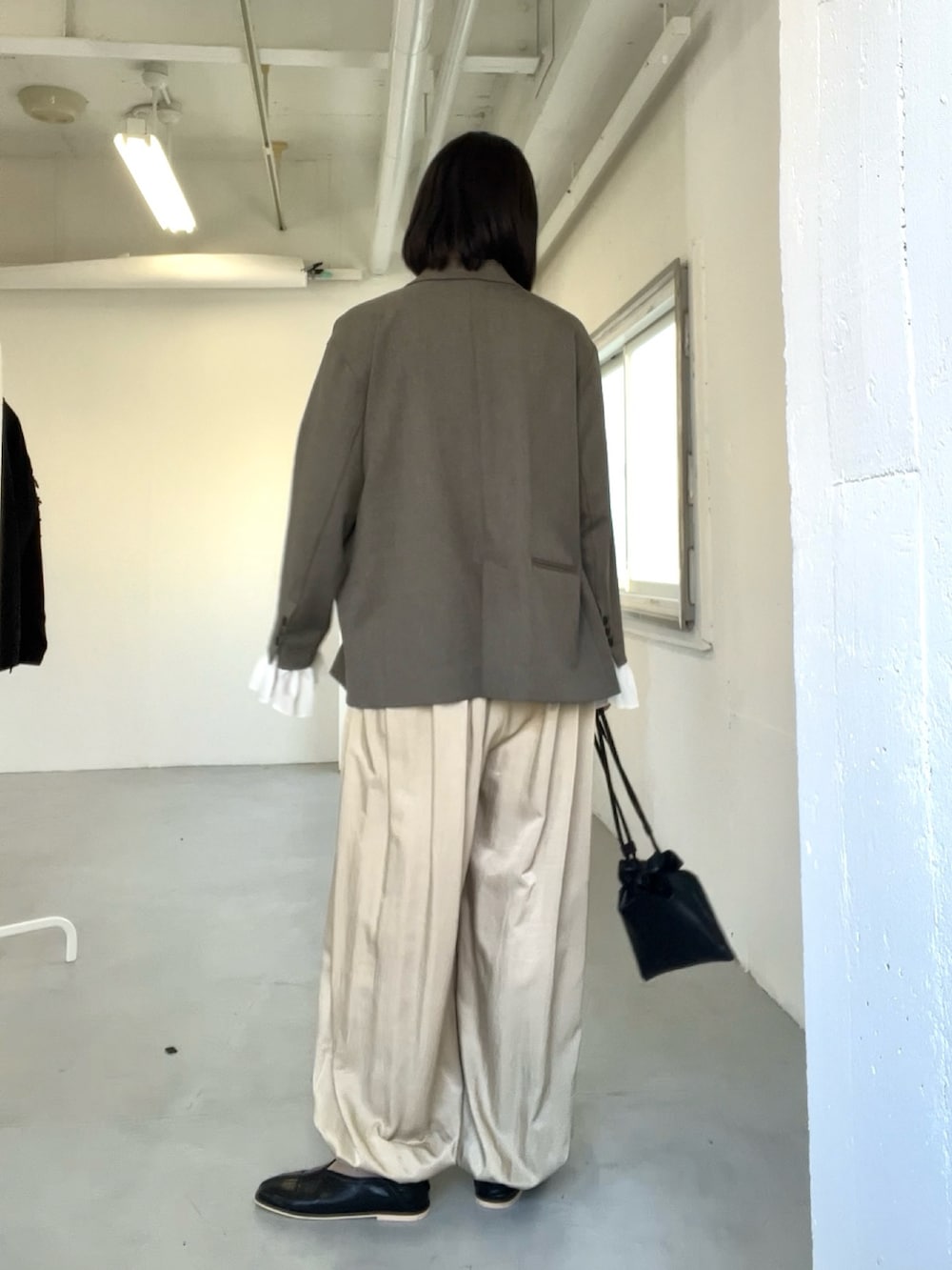 グレー系のその他アウター、ベージュ系のその他パンツ、ブラック系のパンプスを着用したレディースの冬コーディネートの2枚目の写真