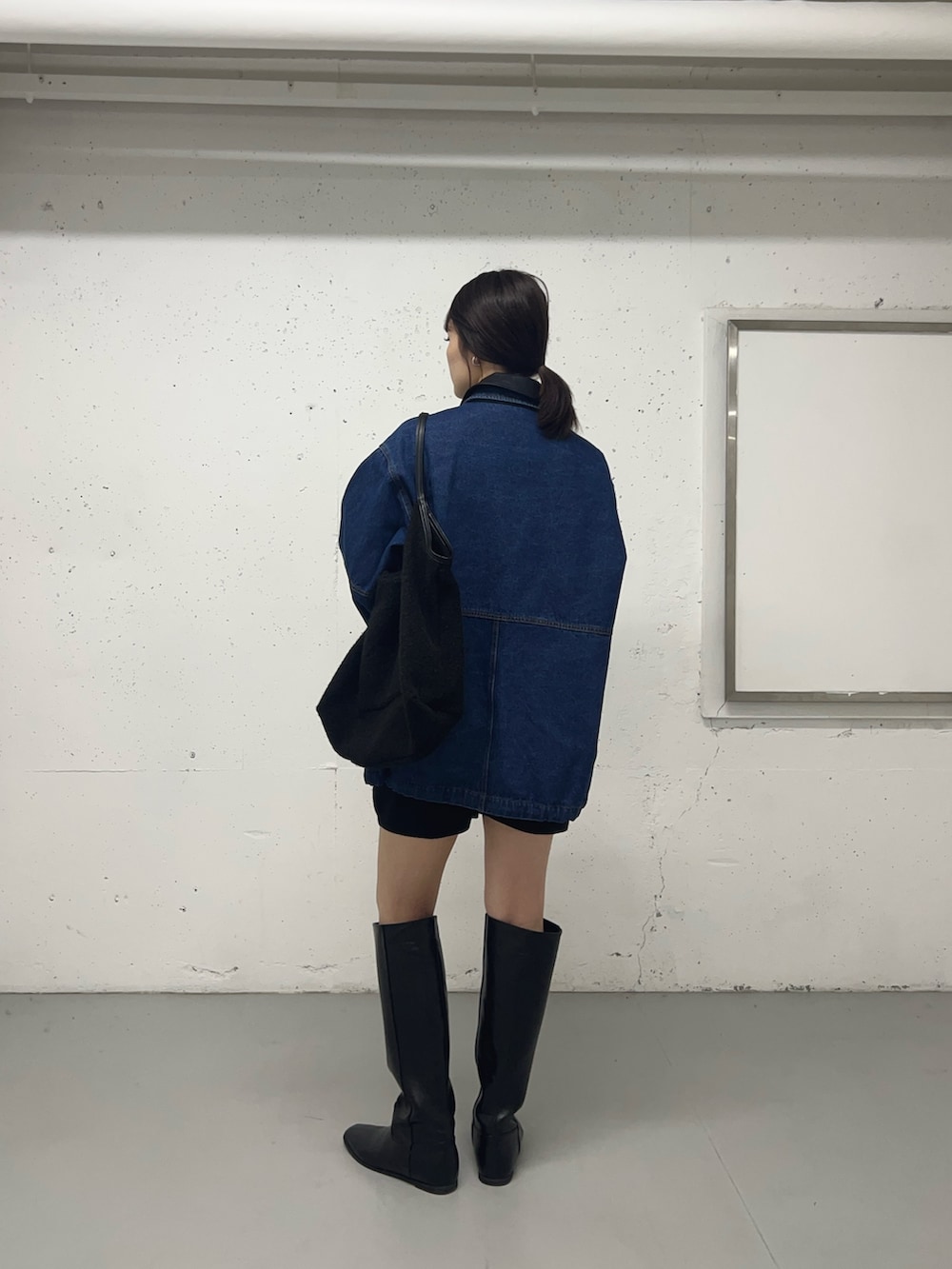 ブルー系のカバーオール、グレー系のその他パンツ、ブラック系のブーツを着用したレディースの秋コーディネートの2枚目の写真