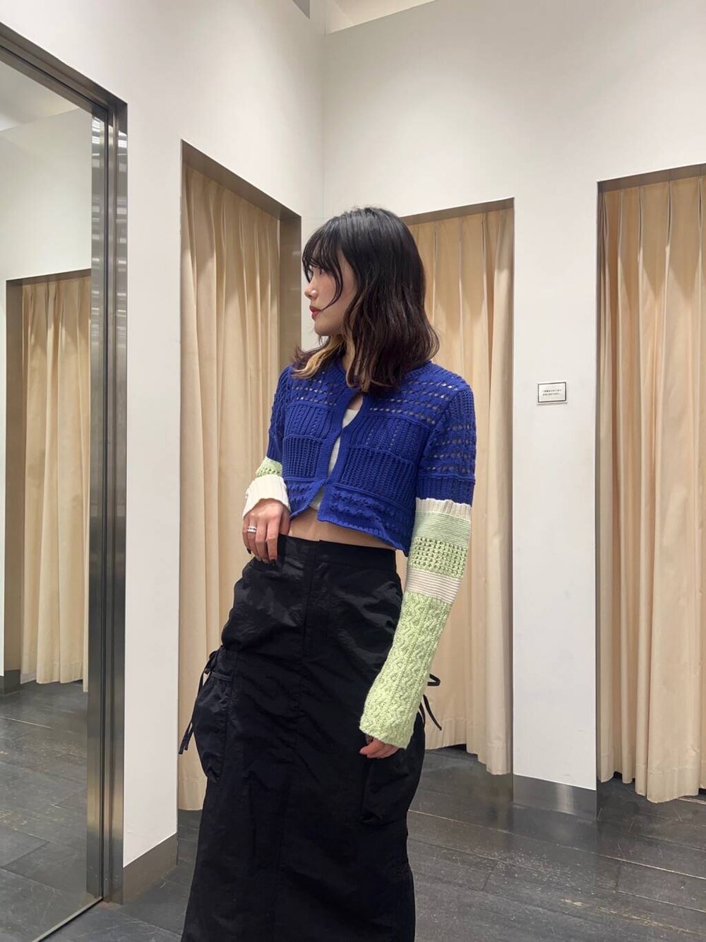 ブルー系のカーディガン/ボレロ、ブラック系のスカートを着用したレディースの春コーディネートの2枚目の写真