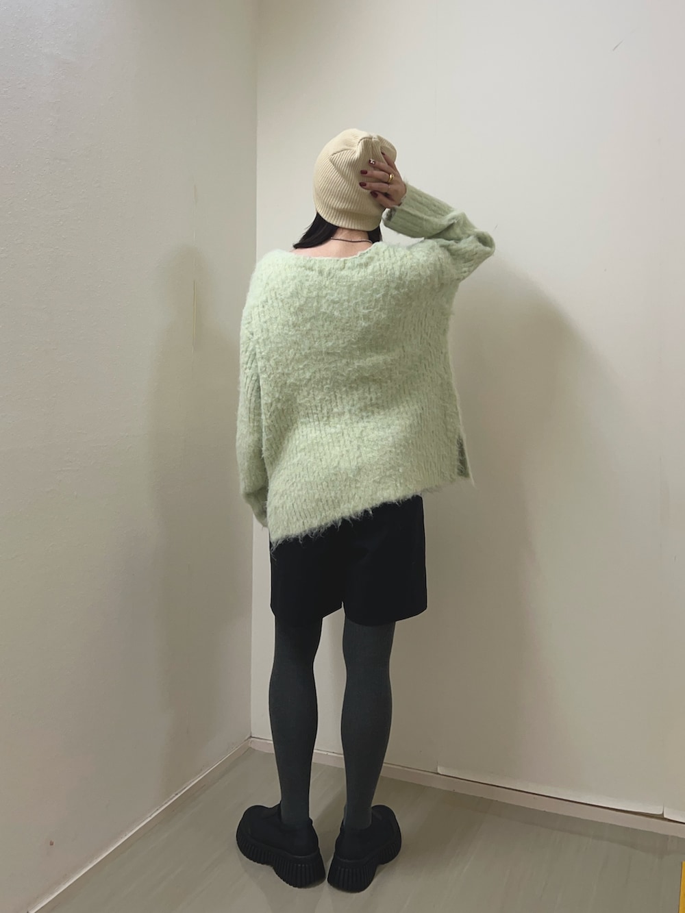 グリーン系のニット/セーター、ブラック系のその他パンツ、ブラック系のスニーカーを着用したレディースの冬コーディネートの2枚目の写真