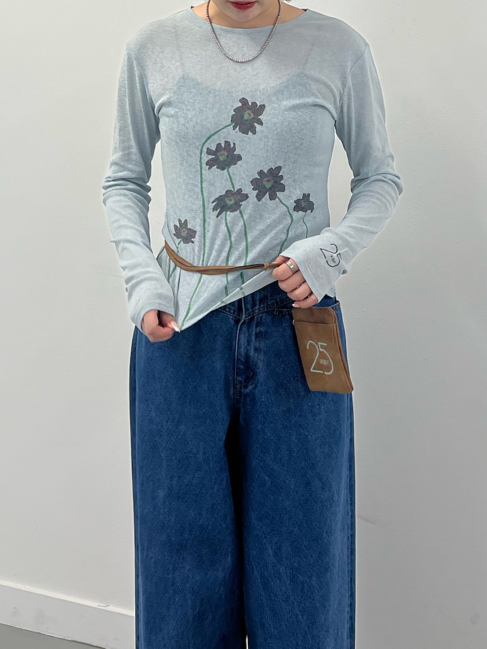 ブルー系のTシャツ/カットソー、ブルー系のデニムパンツ、ブラウン系のポーチを着用したレディースの秋コーディネートの3枚目の写真