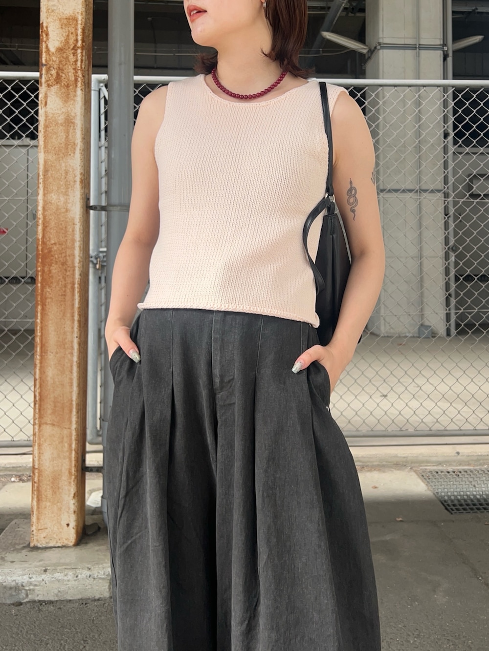 ピンク系のベスト、グレー系のその他パンツ、ブラック系のショルダーバッグを着用したレディースの夏コーディネートの3枚目の写真