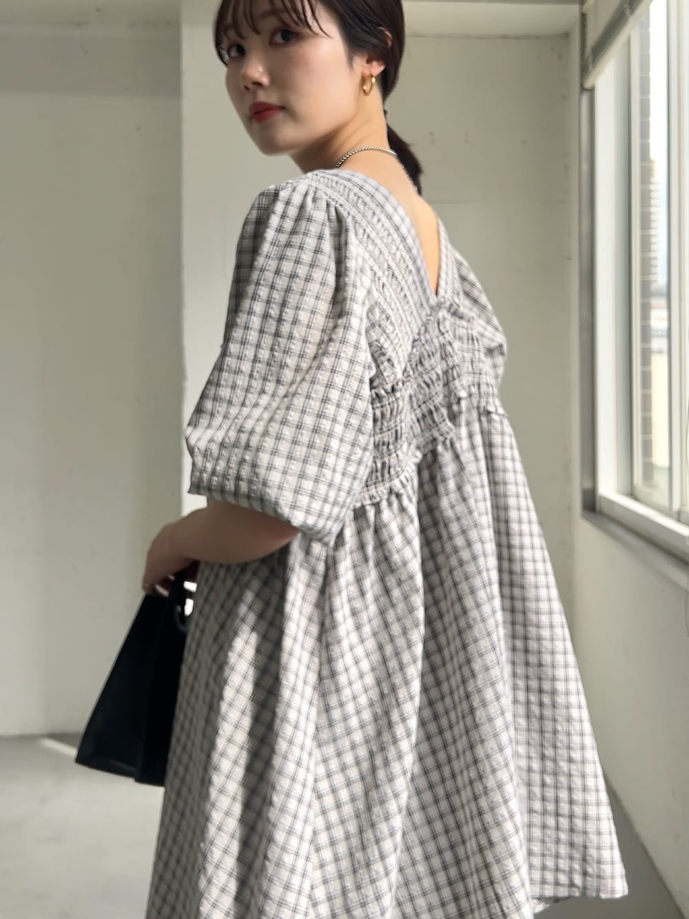 ベージュ系のワンピース、ブラック系のハンドバッグ、グレー系のその他パンツを着用したレディースの春コーディネートの3枚目の写真