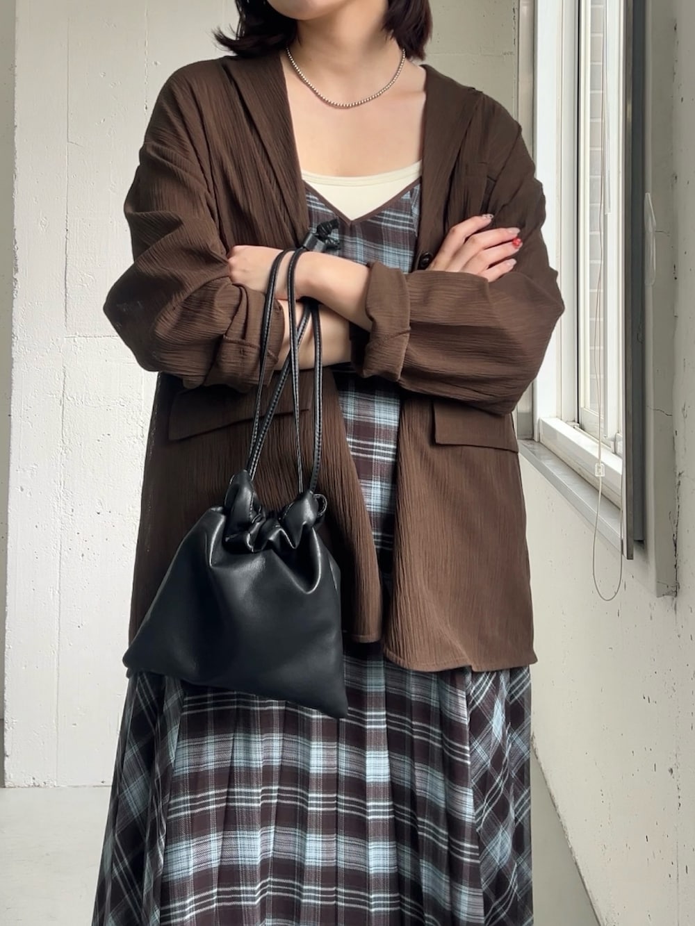 ブラウン系のその他アウター、ブラウン系のワンピース、ブラック系のショルダーバッグを着用したレディースの春コーディネートの2枚目の写真