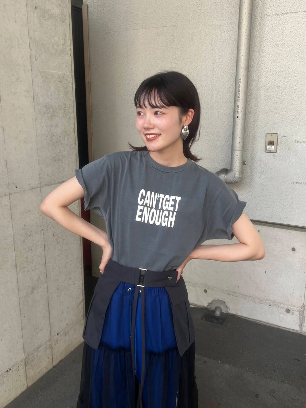 ホワイト系のスニーカー、グレー系のスカート、ブルー系のその他パンツを着用したレディースの夏コーディネートの3枚目の写真