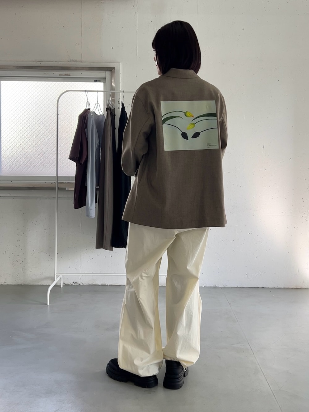 ベージュ系のその他アウター、ブラック系のボストンバッグ、ブラック系のスニーカーを着用したレディースの冬コーディネートの2枚目の写真