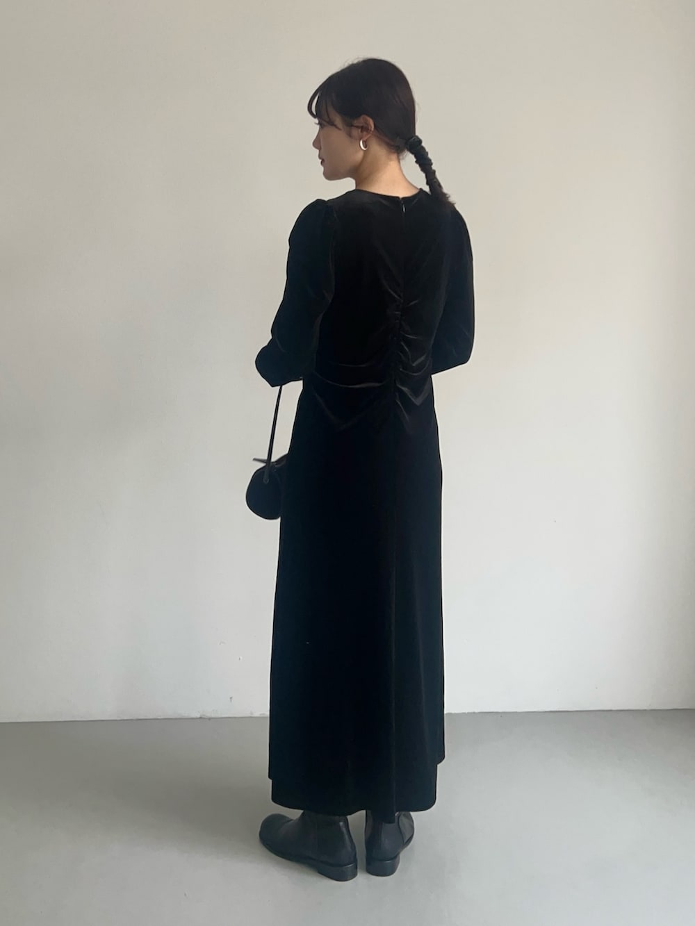 ブラック系のワンピース、ブラウン系のショルダーバッグ、ブラック系のブーツを着用したレディースの秋コーディネートの3枚目の写真