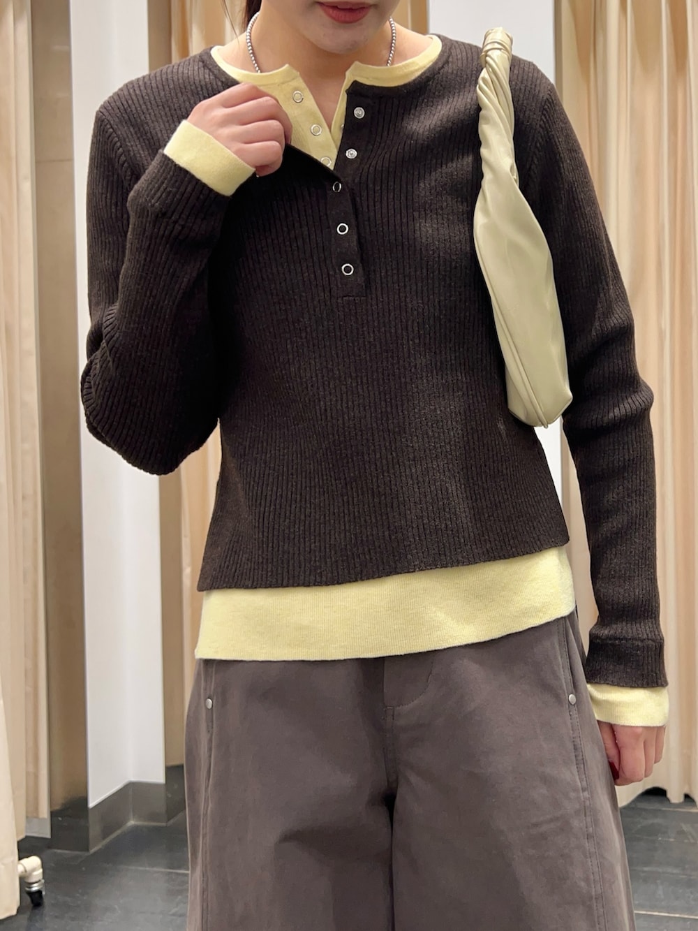 ブラウン系のニット/セーター、ホワイト系のハンドバッグ、グレー系のその他パンツを着用したレディースの冬コーディネートの3枚目の写真