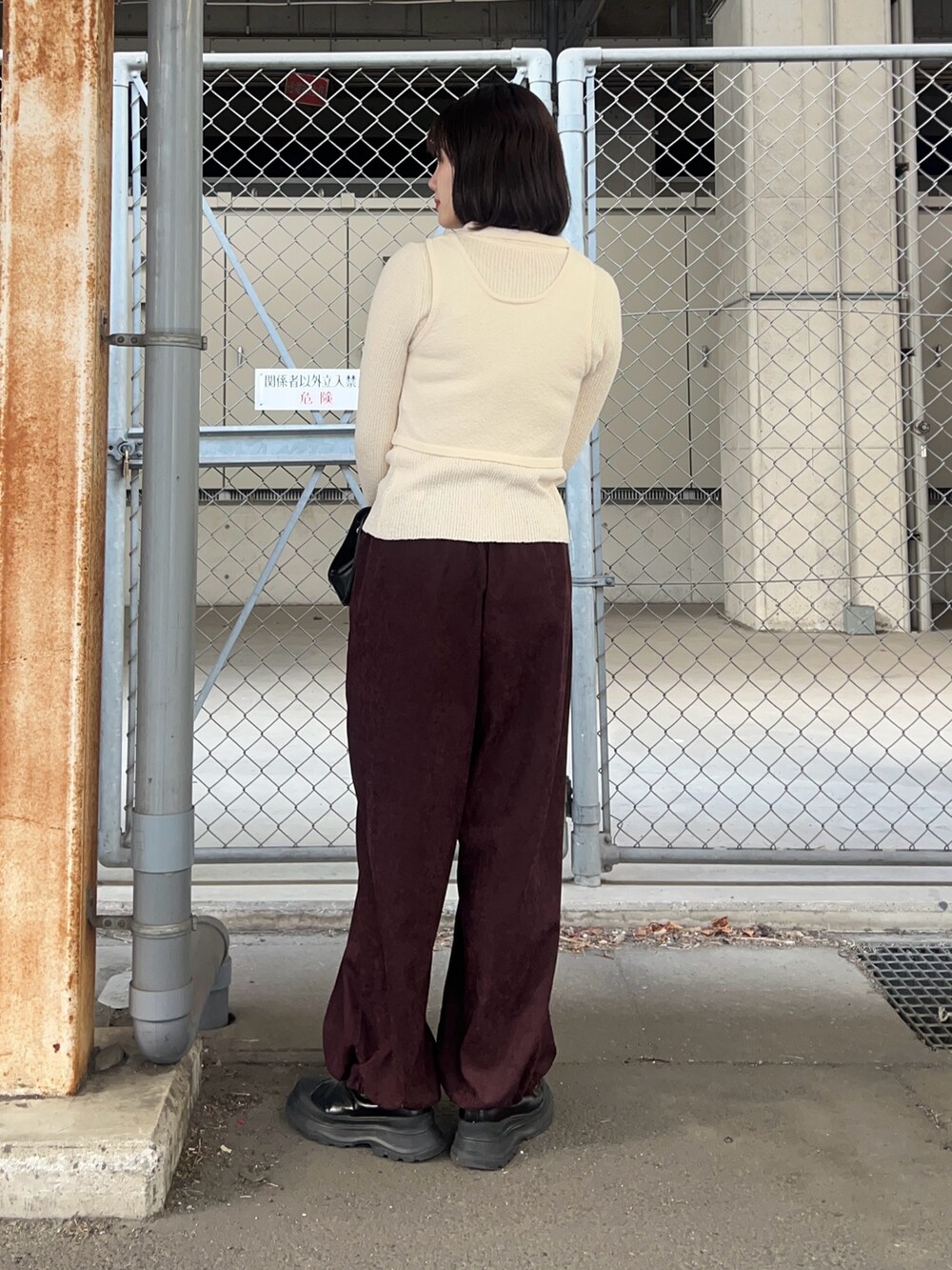 ホワイト系のニット/セーター、レッド系のその他パンツ、ブラック系のボストンバッグを着用したレディースの冬コーディネートの2枚目の写真