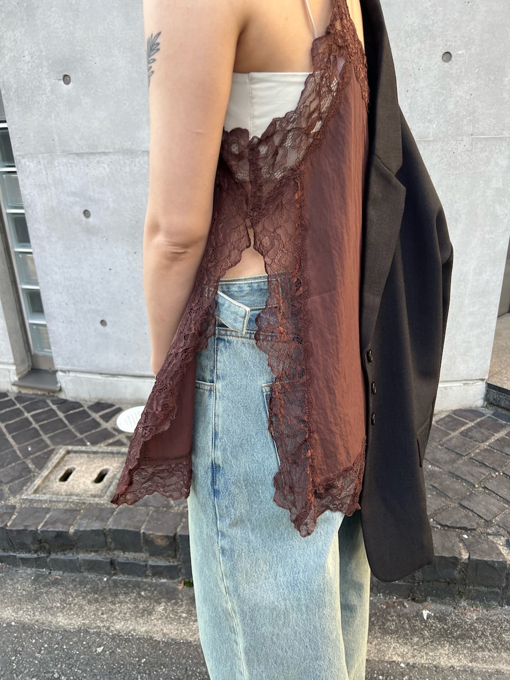 グレー系のその他アウター、ブラウン系のキャミソール、ブルー系のデニムパンツを着用したレディースの冬コーディネートの3枚目の写真