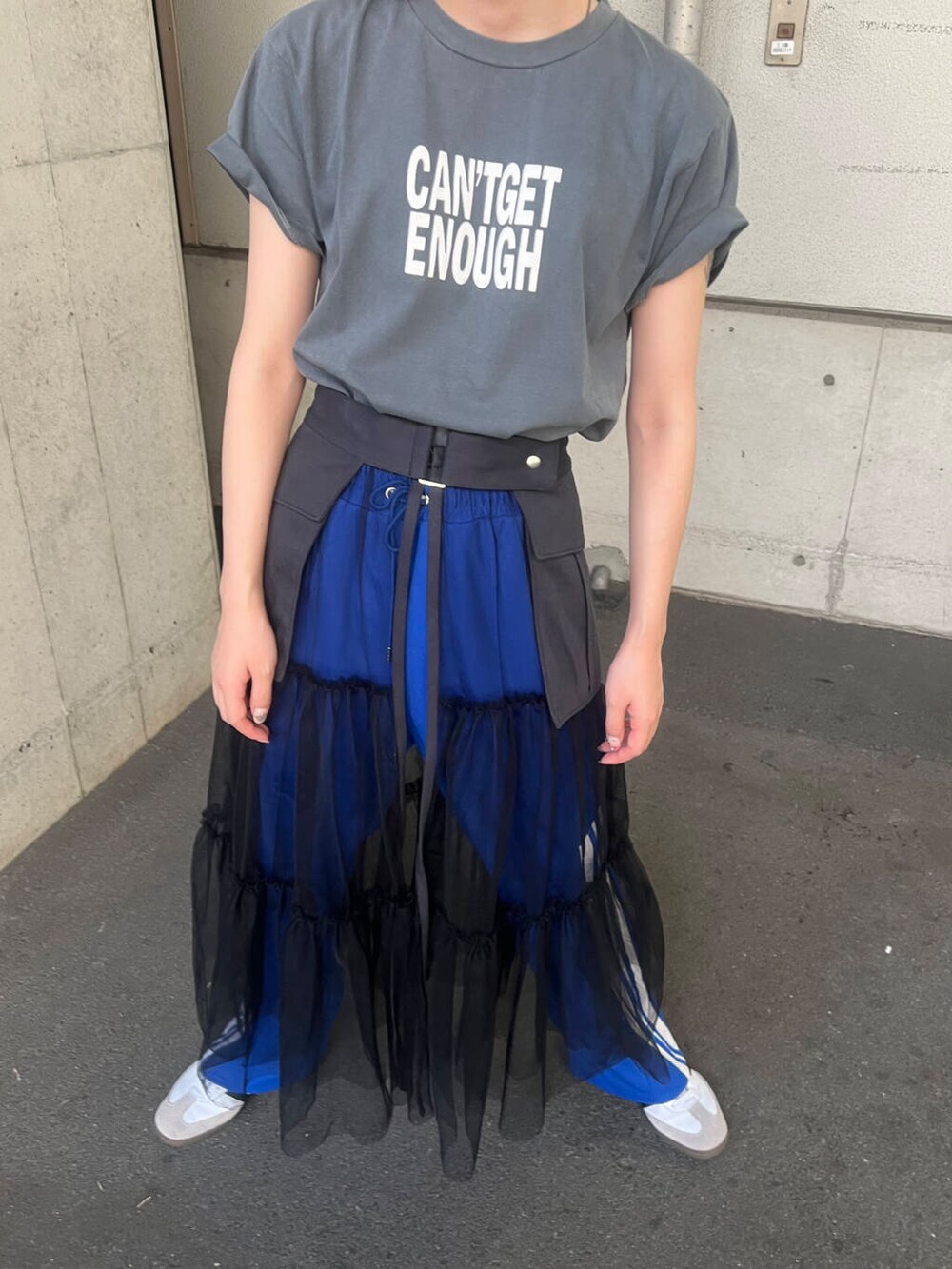 ホワイト系のスニーカー、グレー系のスカート、ブルー系のその他パンツを着用したレディースの夏コーディネートの2枚目の写真