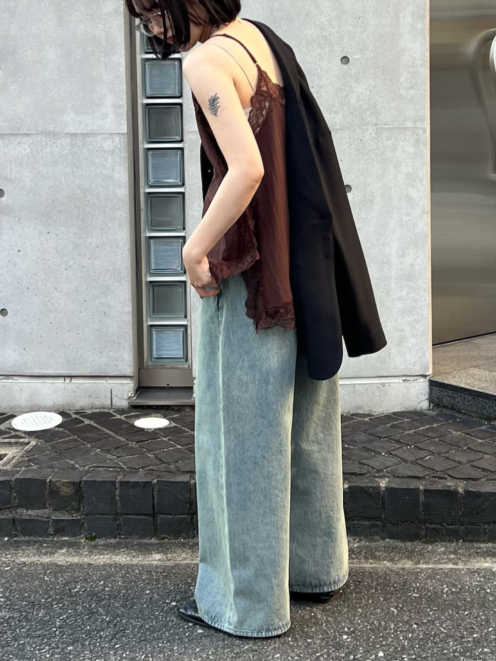 グレー系のその他アウター、ブラウン系のキャミソール、ブルー系のデニムパンツを着用したレディースの冬コーディネートの2枚目の写真