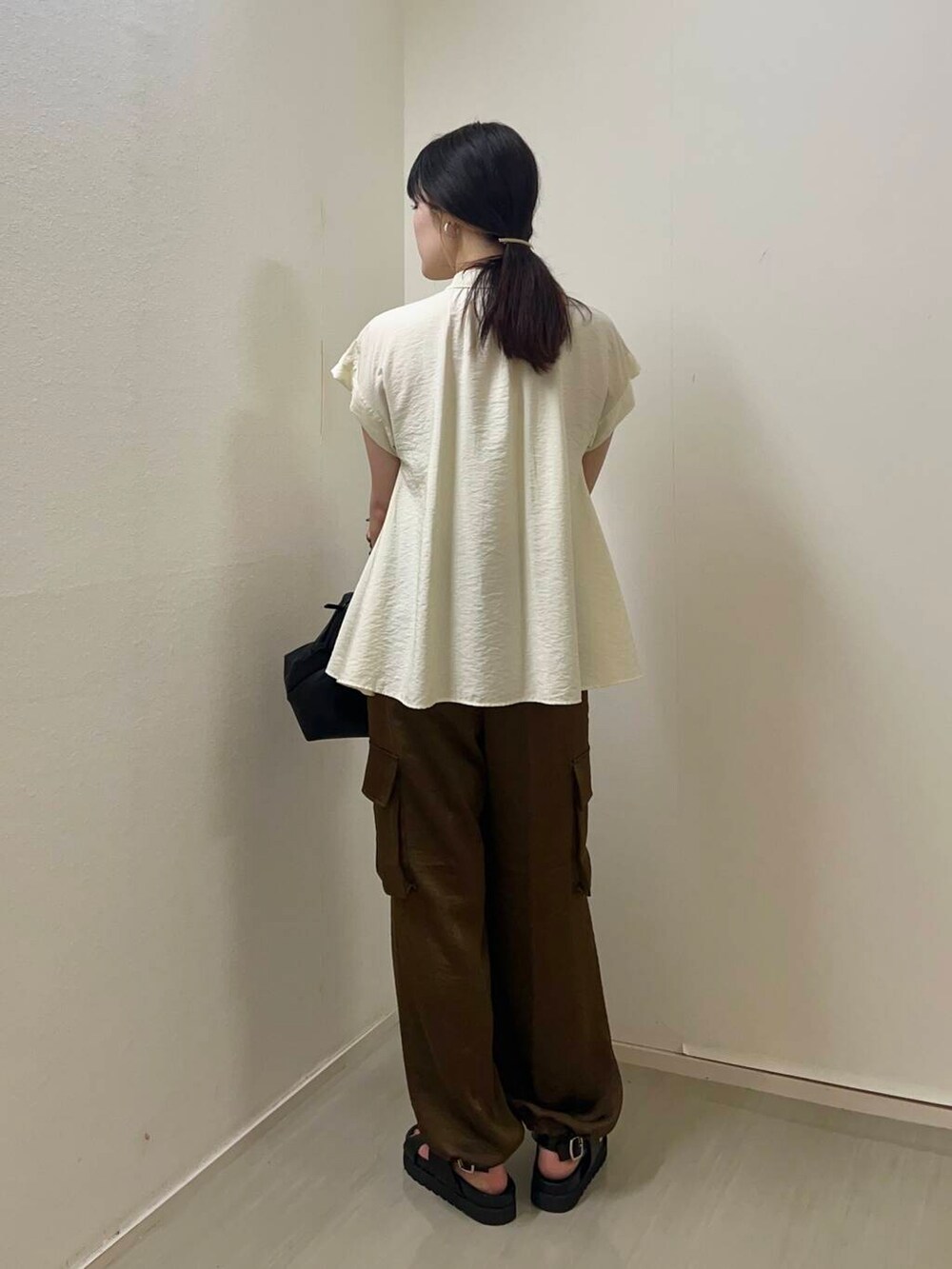 ブラウン系のその他パンツ、ホワイト系のシャツ/ブラウス、ブラック系のサンダルを着用したレディースの夏コーディネートの2枚目の写真
