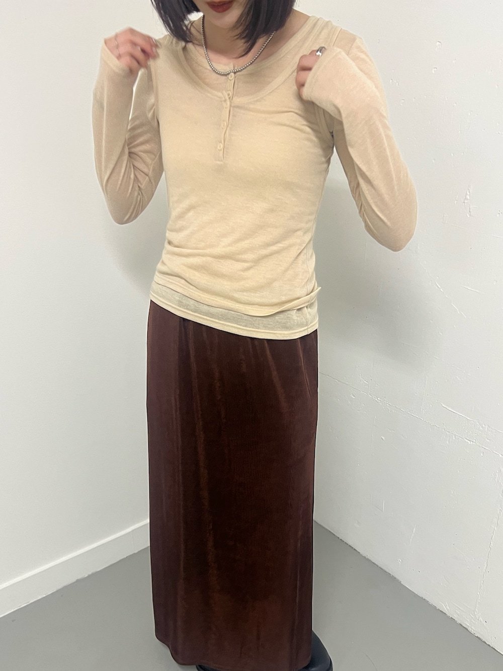 ベージュ系のTシャツ/カットソー、ブラウン系のスカートを着用したレディースの冬コーディネートの3枚目の写真