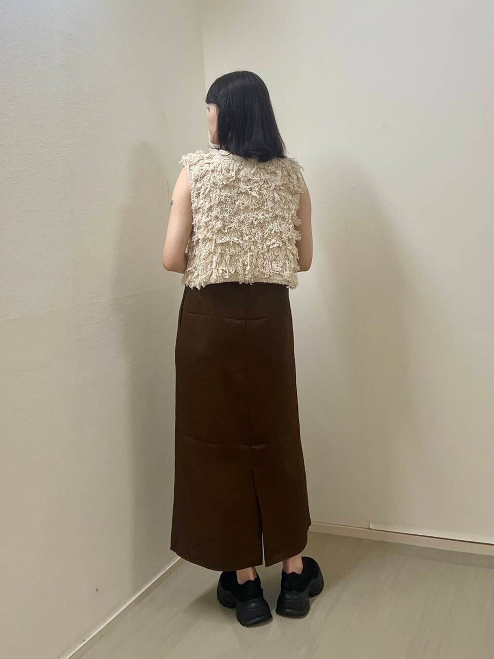 ブラウン系のワンピース、ベージュ系のベストを着用したレディースの夏コーディネートの2枚目の写真