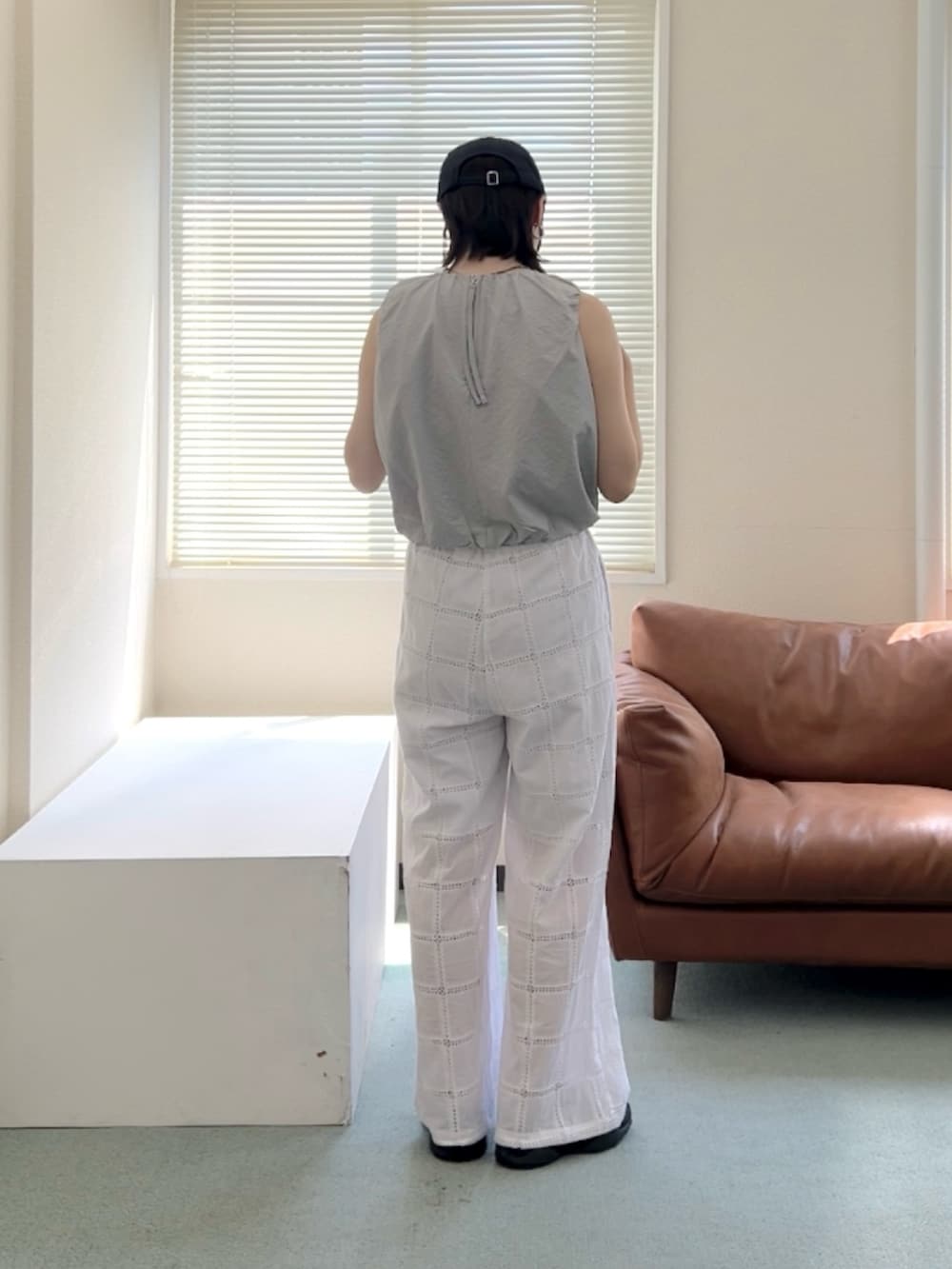 グレー系のシャツ/ブラウス、ホワイト系のその他パンツ、ブラック系のスニーカーを着用したレディースの夏コーディネートの2枚目の写真
